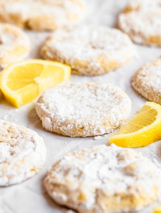 Lemon cooler cookies on a white backround with lemon slices.
