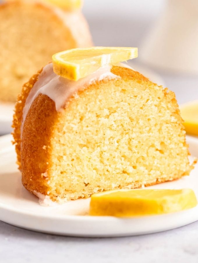 Slice of lemonade bundt cake on a white plate.