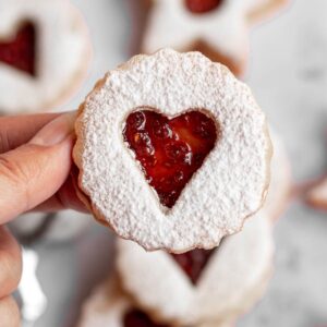 Hand holding a linzer cookie.