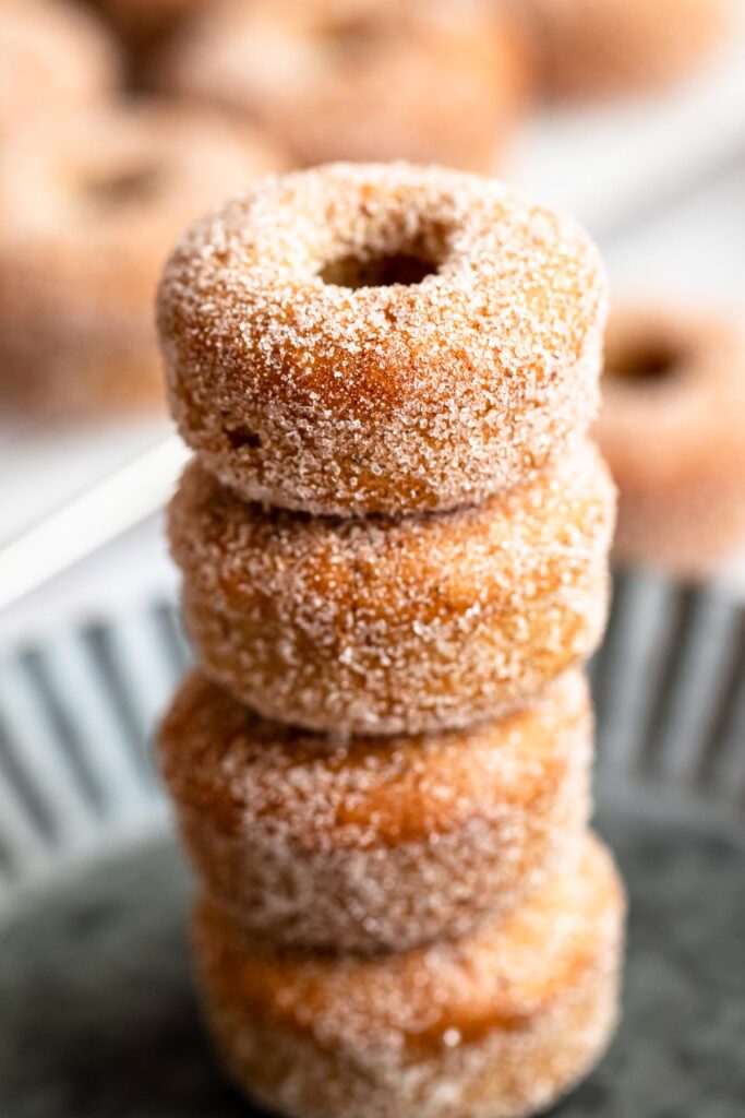 Stack of mini donuts on a gray plate.