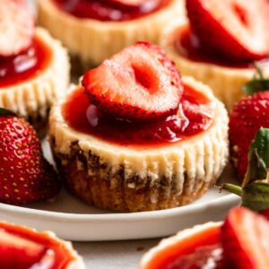 Mini strawberry cheesecakes on a plate.