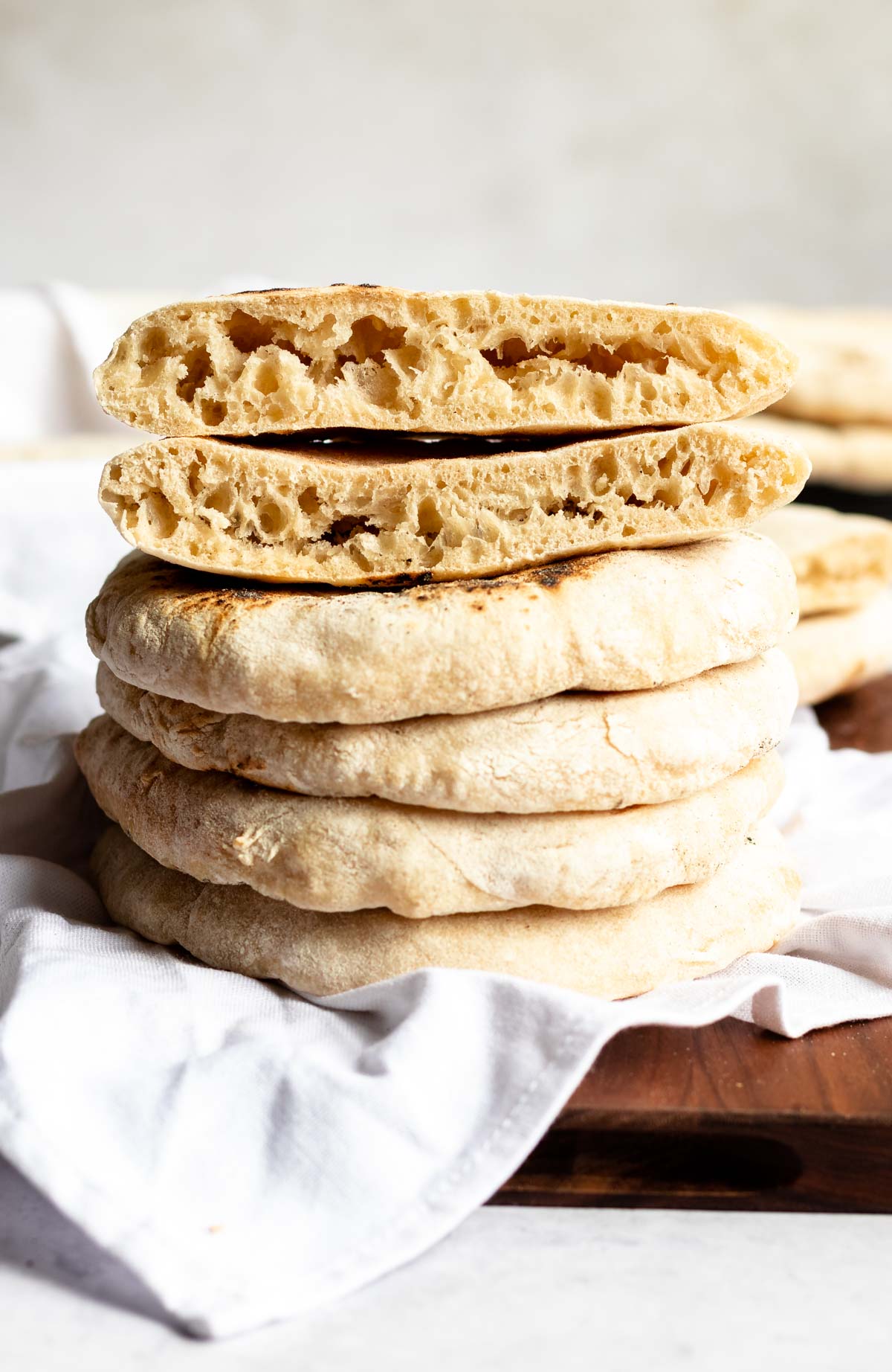 Stack of pitas with one pita cut in half.