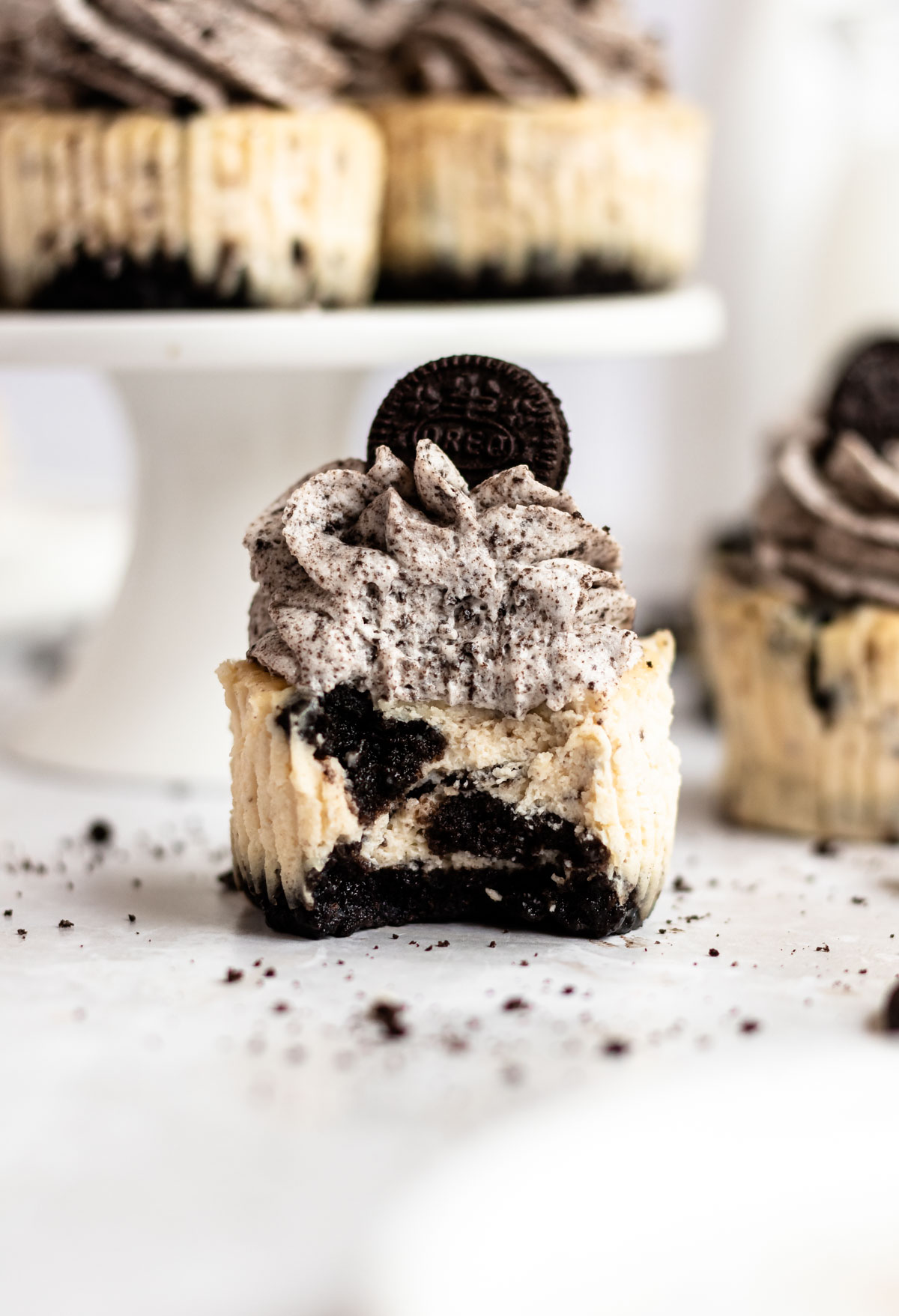 Bite missing from a oreo cheesecake cupcakes.
