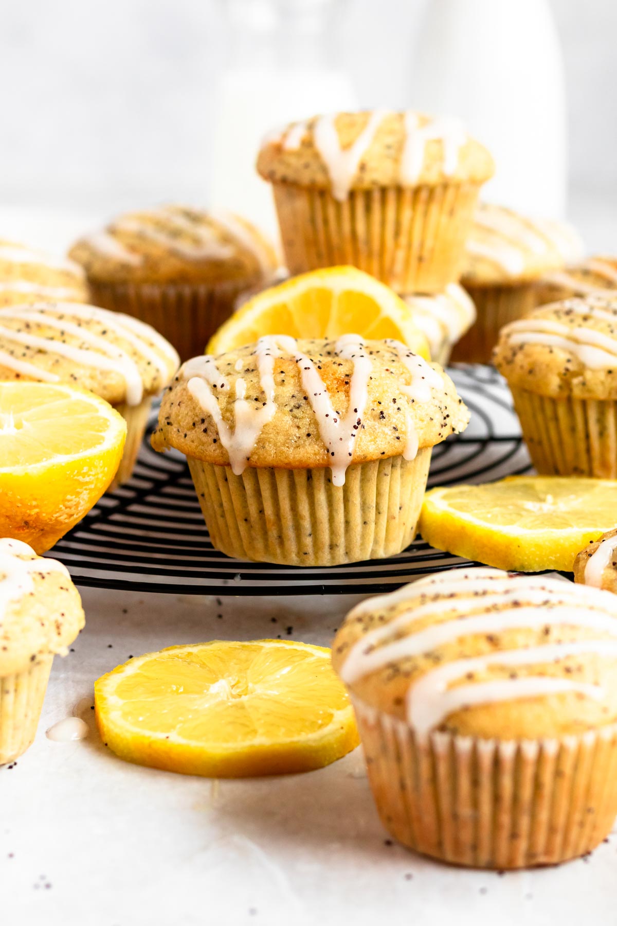 Lemon poppy seed muffins with lemon glaze on a round cooling rack.