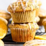 Stack of two lemon poppy seed muffins with lemon glaze on top.