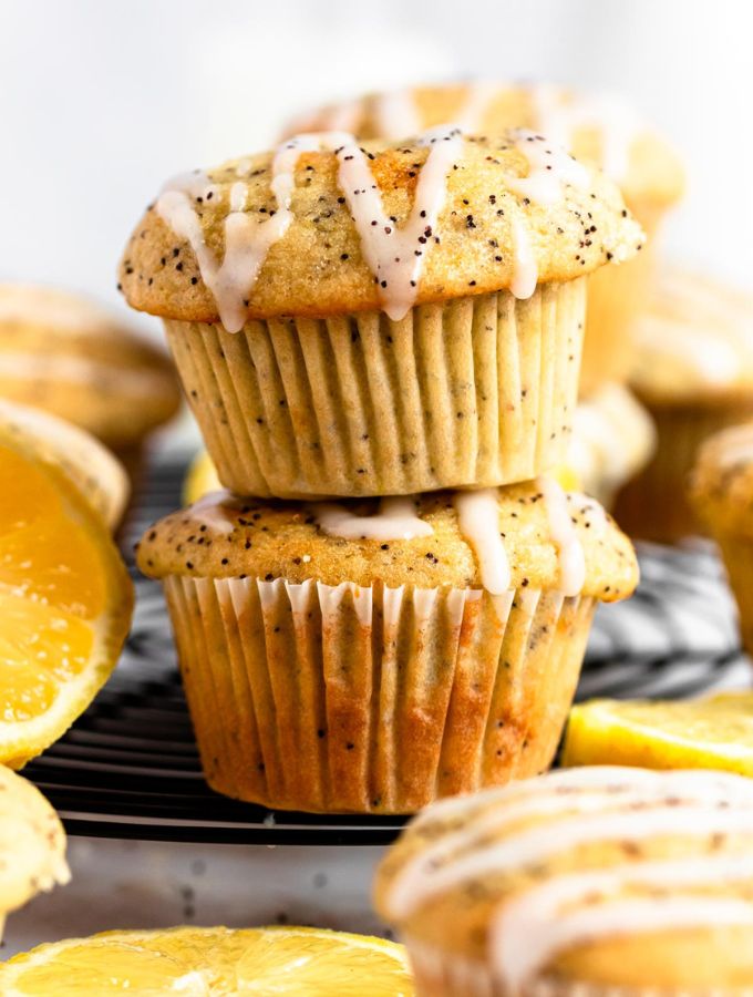 Stack of two lemon poppy seed muffins with lemon glaze on top.