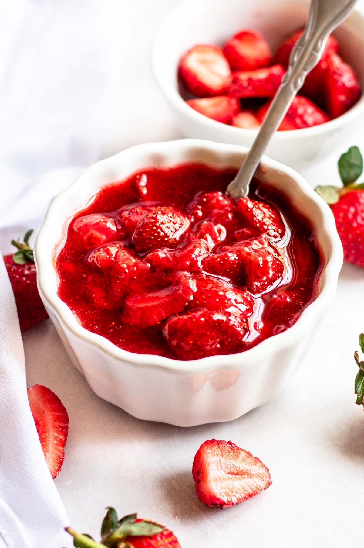 Strawberry topping for cheesecake in a white bowl.