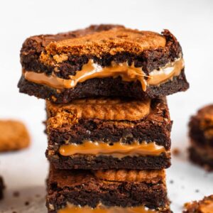 Stack of biscoff brownies with the top one missing a bite.
