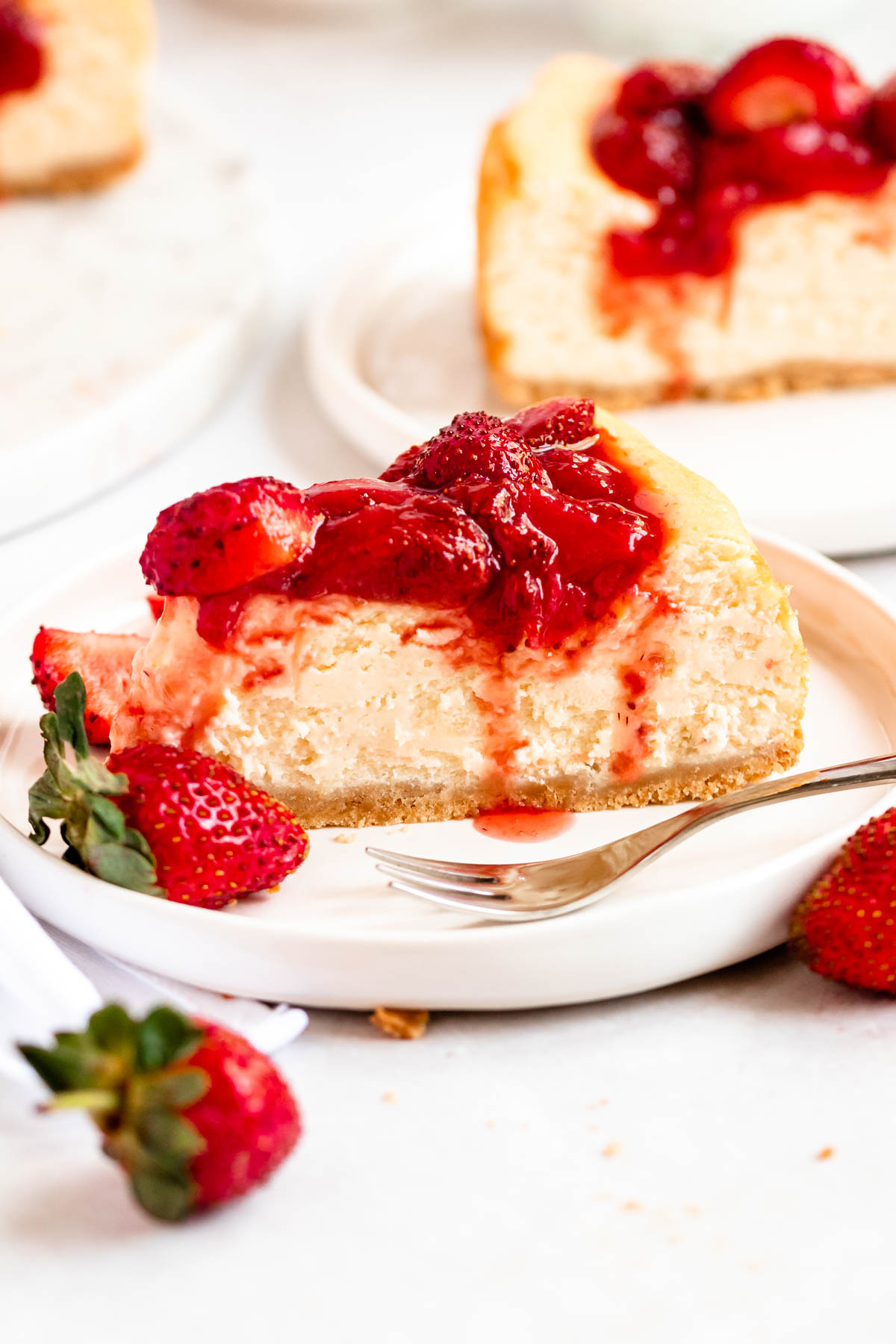 Slice of strawberry cheesecake on a plate.