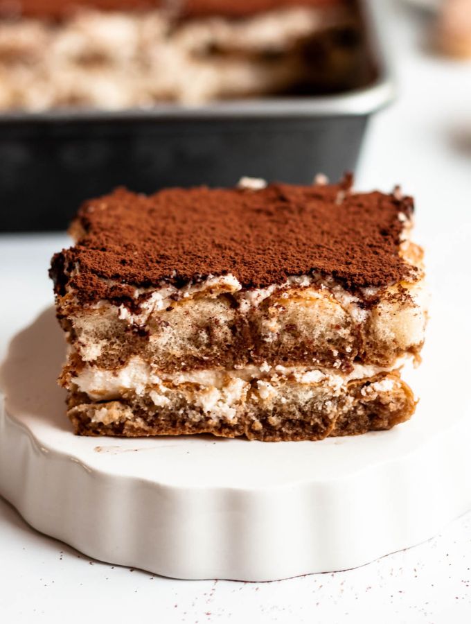 Slice of tiramisu on a white plate.