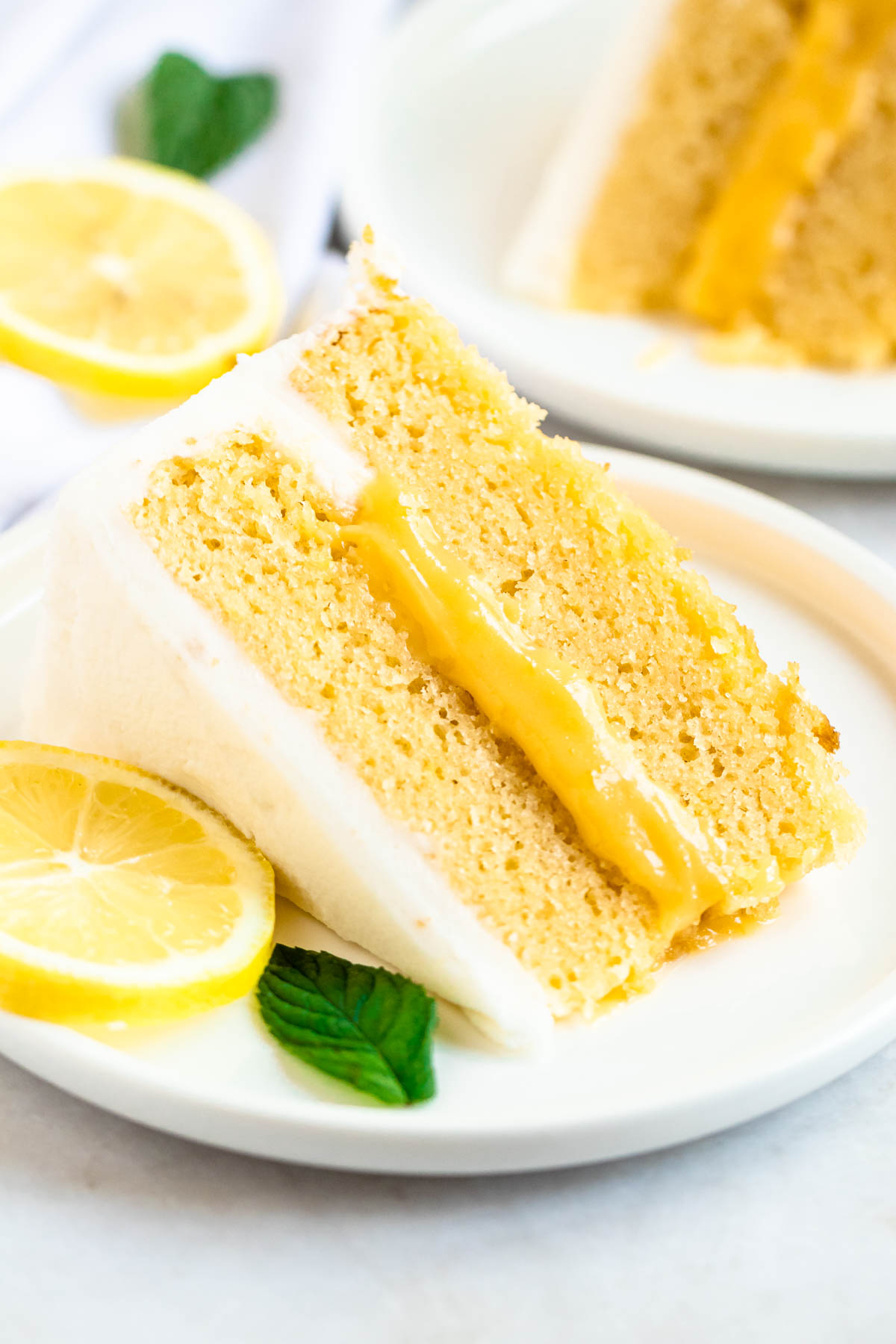 Slice of lemon curd cake on a white plate.