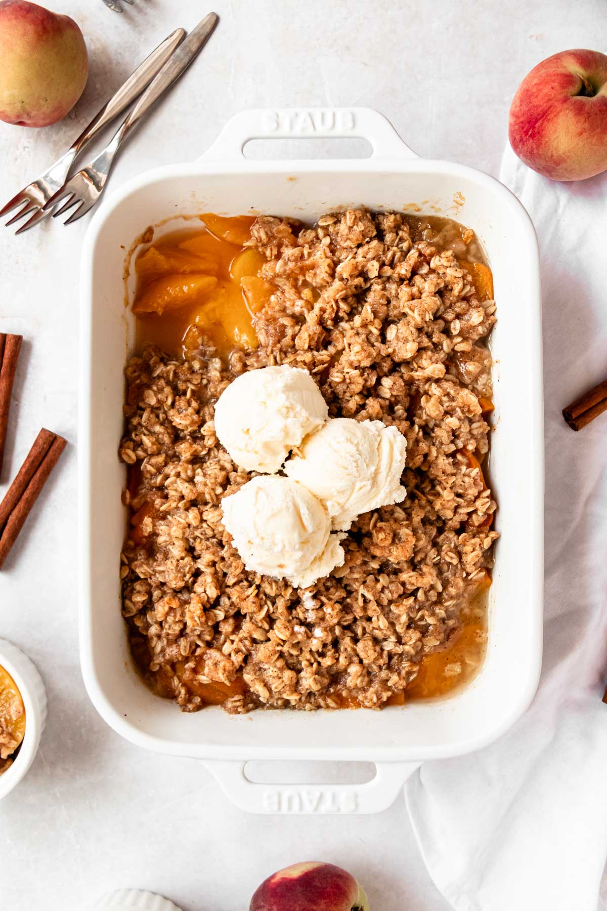 Overhead shot of peach crisp with canned peaches with vanilla ice cream.