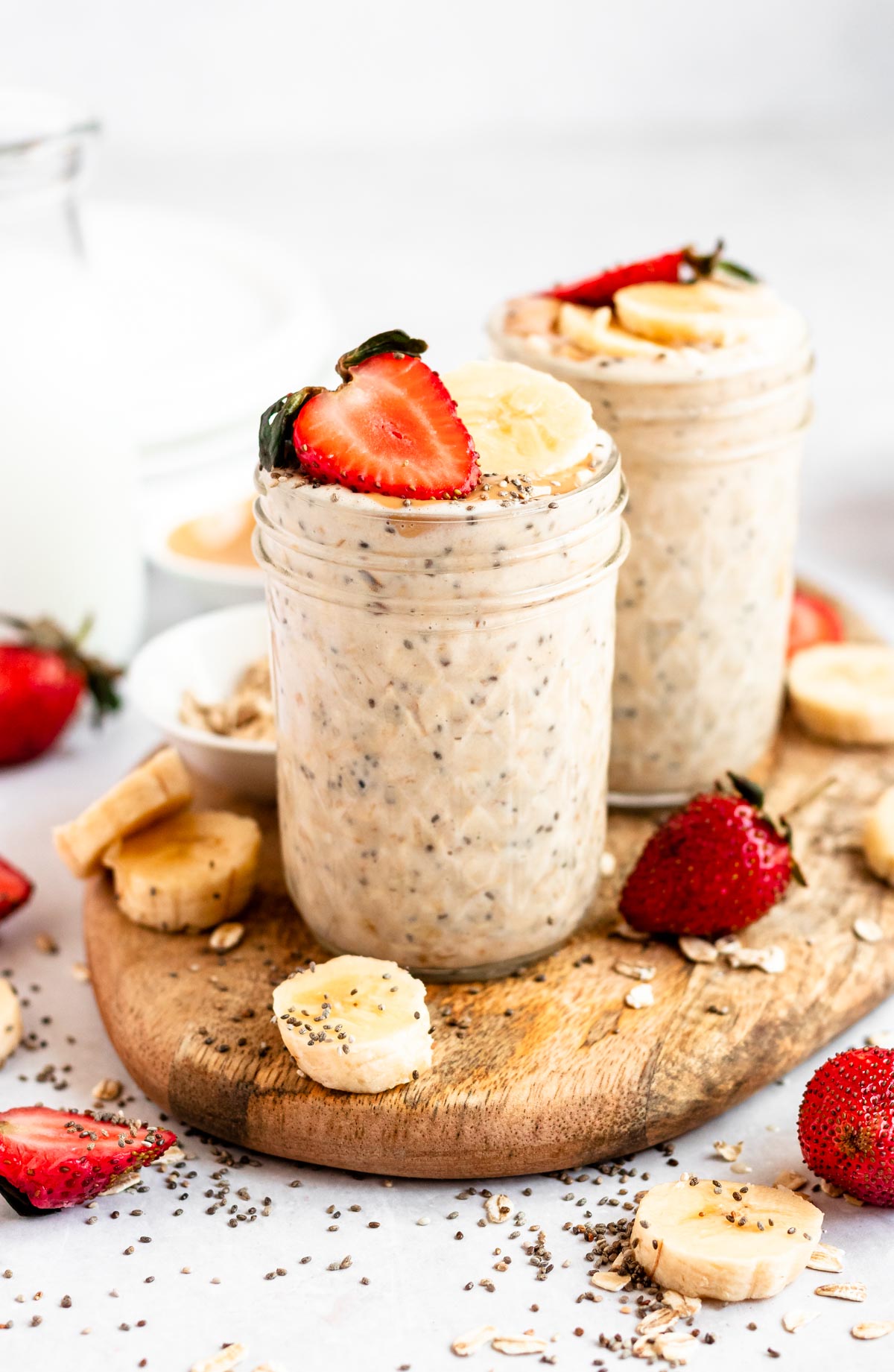 Two jars of protein overnight oats on a wooden surface.