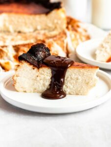 Slice of san sebastian cheesecake with chocolate ganache on top.