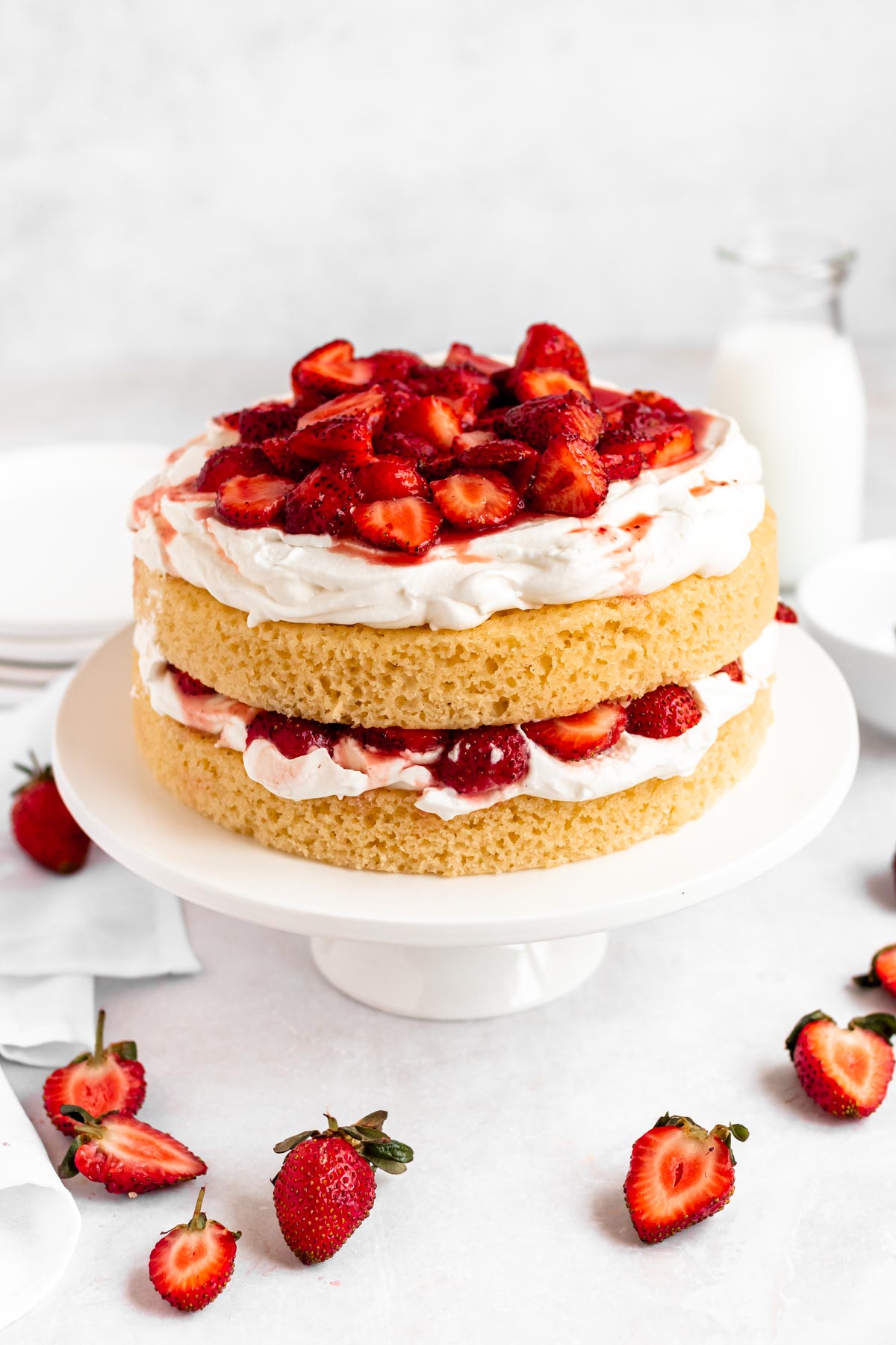 Strawberry shortcake birthday cake on a white cake plate.