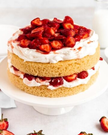 Strawberry shortcake cake on a white cake platter.