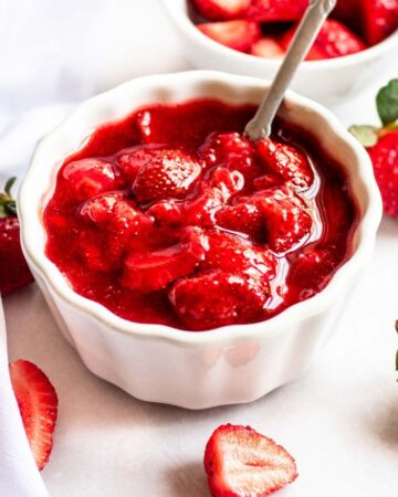 Strawberry topping for cheesecake in a white bowl.