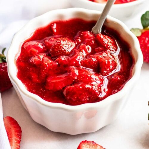 Strawberry topping for cheesecake in a white bowl.