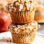 Stack of two apple crumble muffins on a plate.