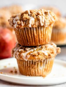 Stack of two apple crumble muffins on a plate.