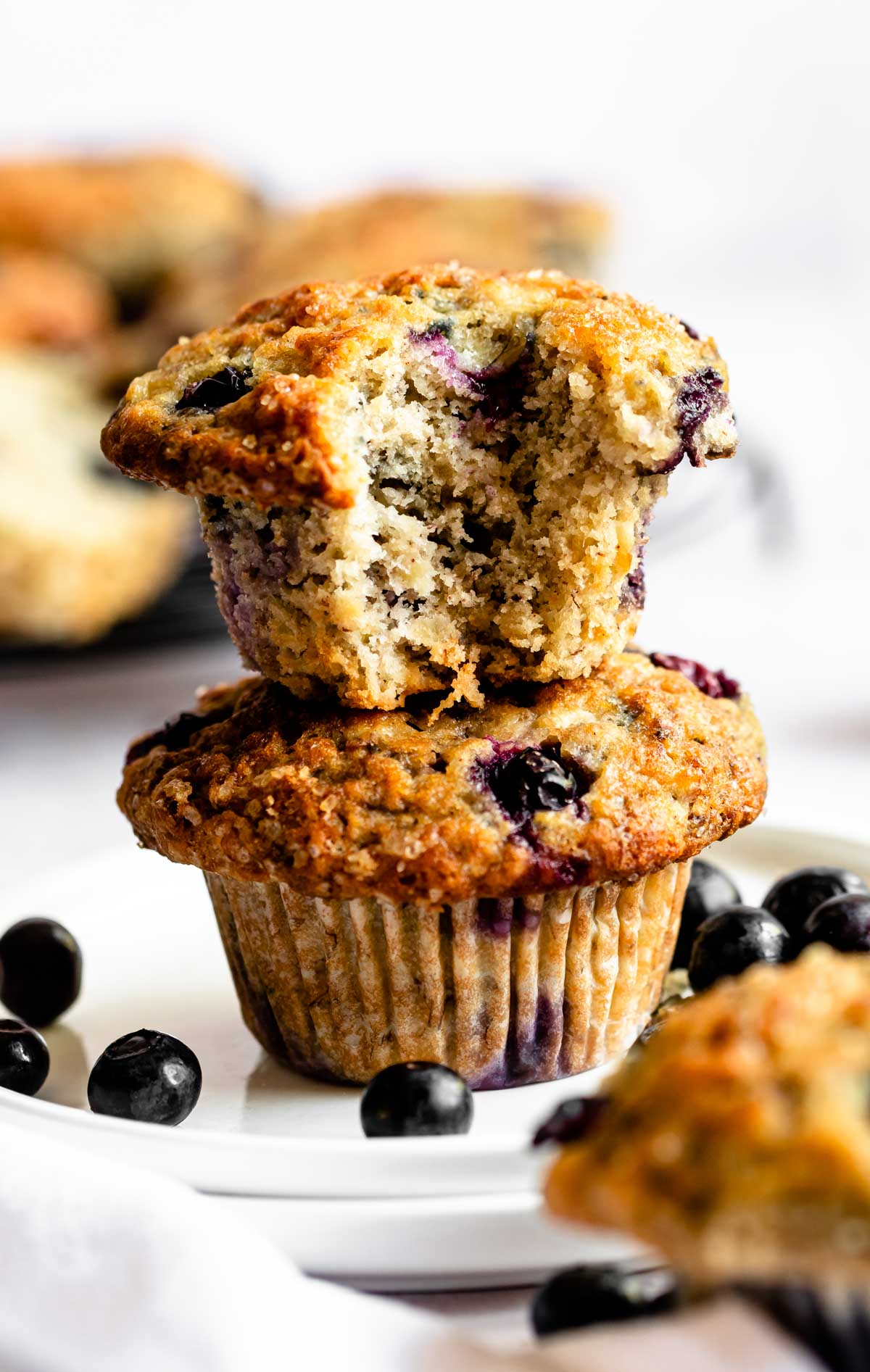 Stack of two muffins with a bite missing from the top one.
