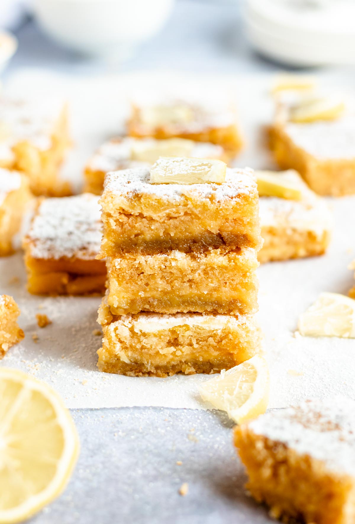 Stack of lemon bars on a white parchment paper.