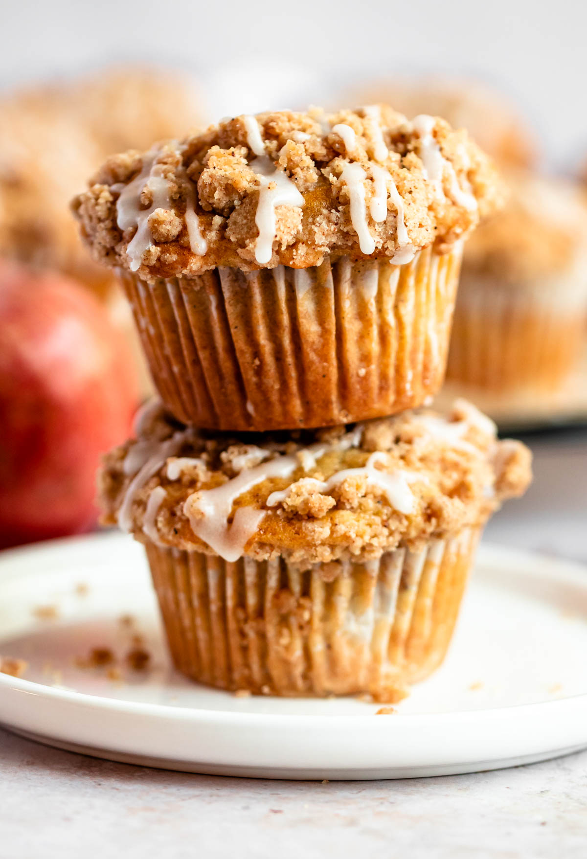 Stack of two apple crumble muffins on a plate.