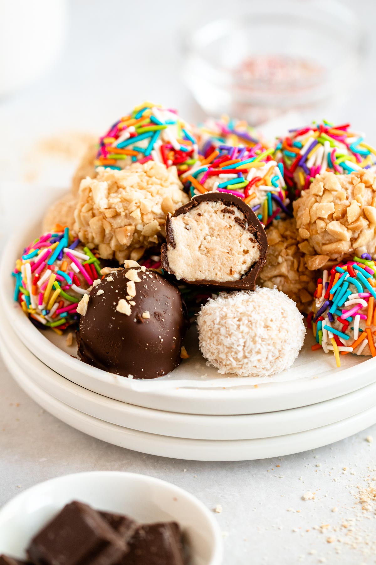 Cheesecake balls on a plate with the top one missing a bite.