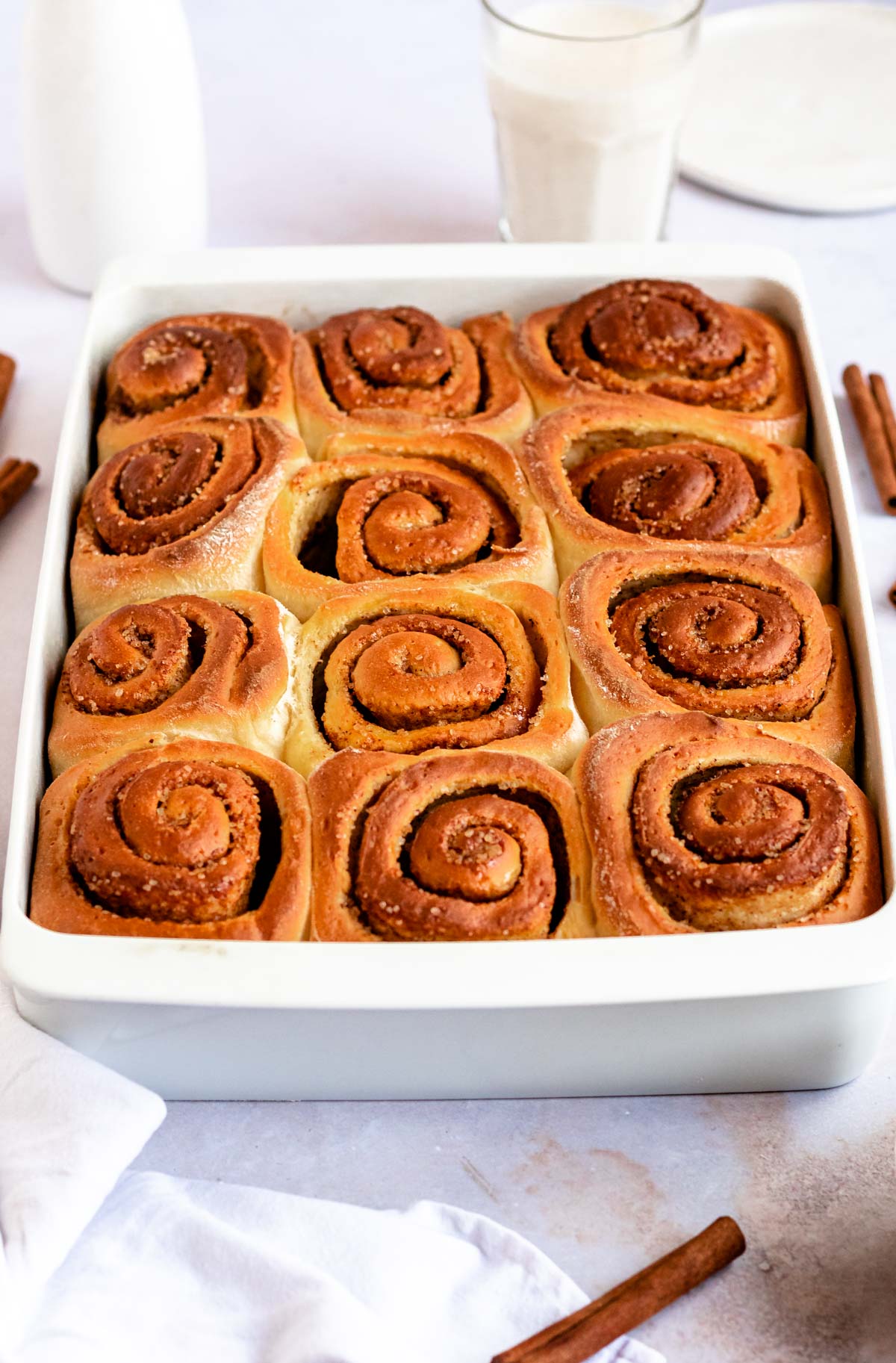 Shot of baked cinnamon rolls without a glaze in a baking pan.