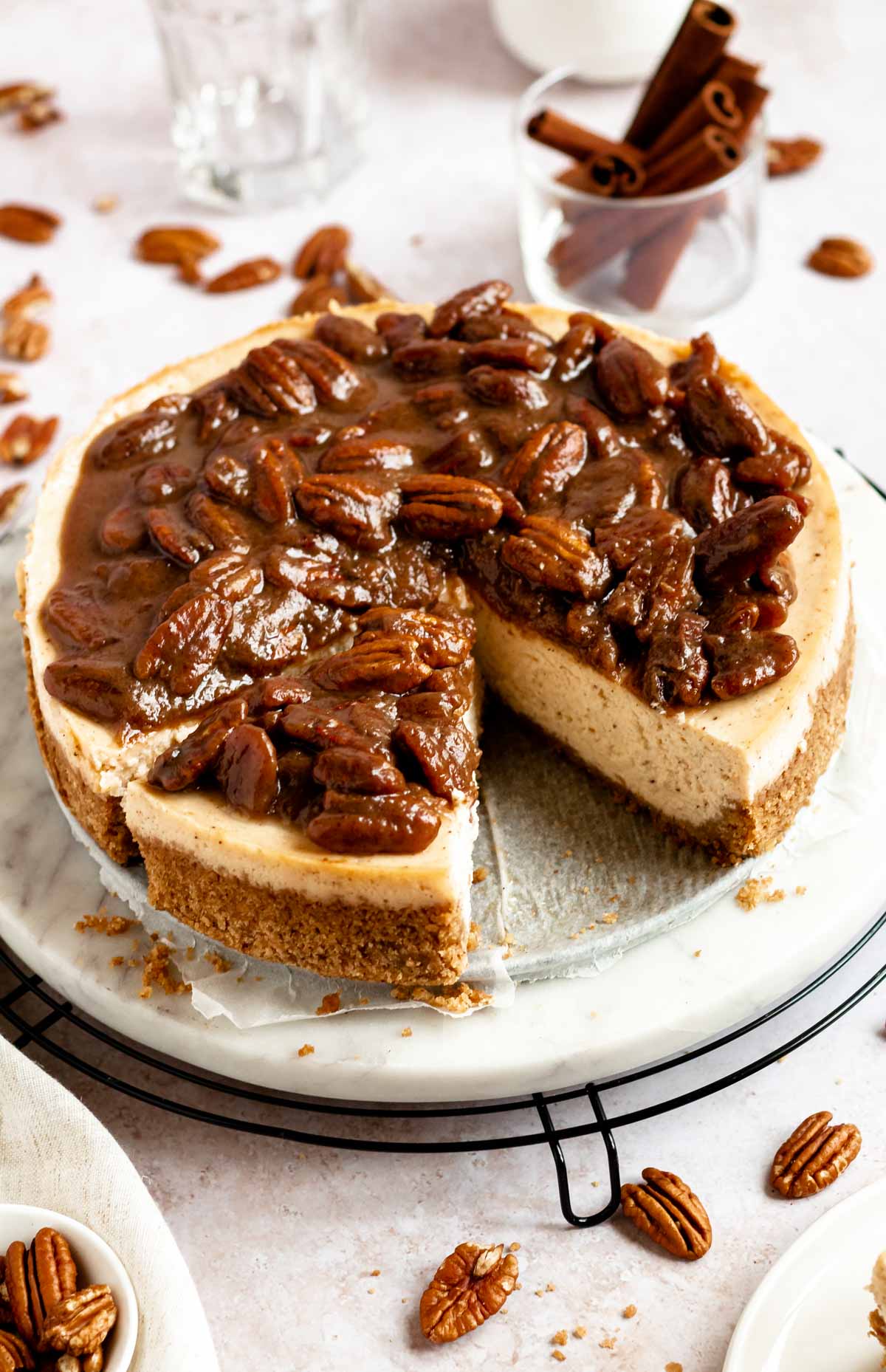 Slice missing from a caramel pecan cheesecake.