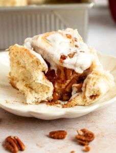 Bite missing from apple cinnamon rolls with apple pie filling.