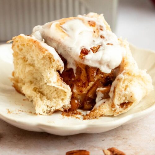 Bite missing from apple cinnamon rolls with apple pie filling.