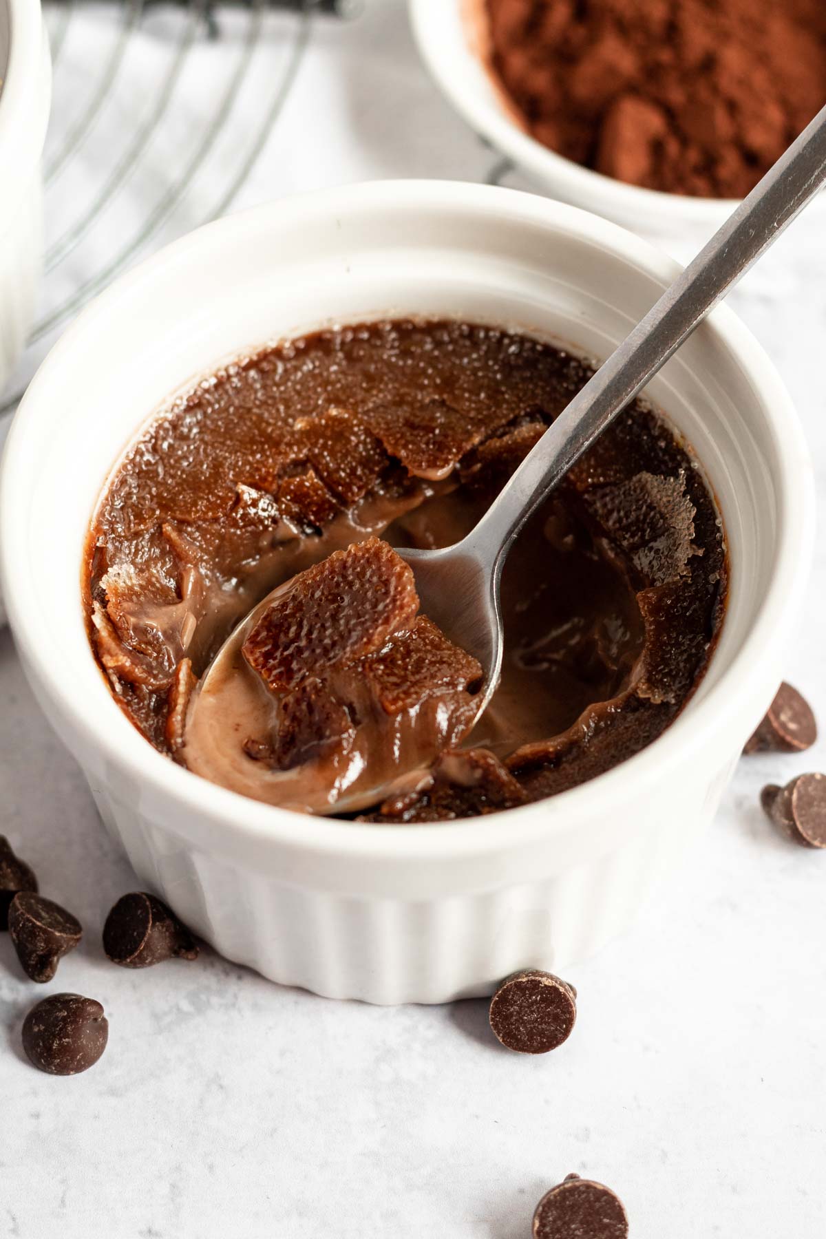 Spoon inserted into a chocolate creme brulee.