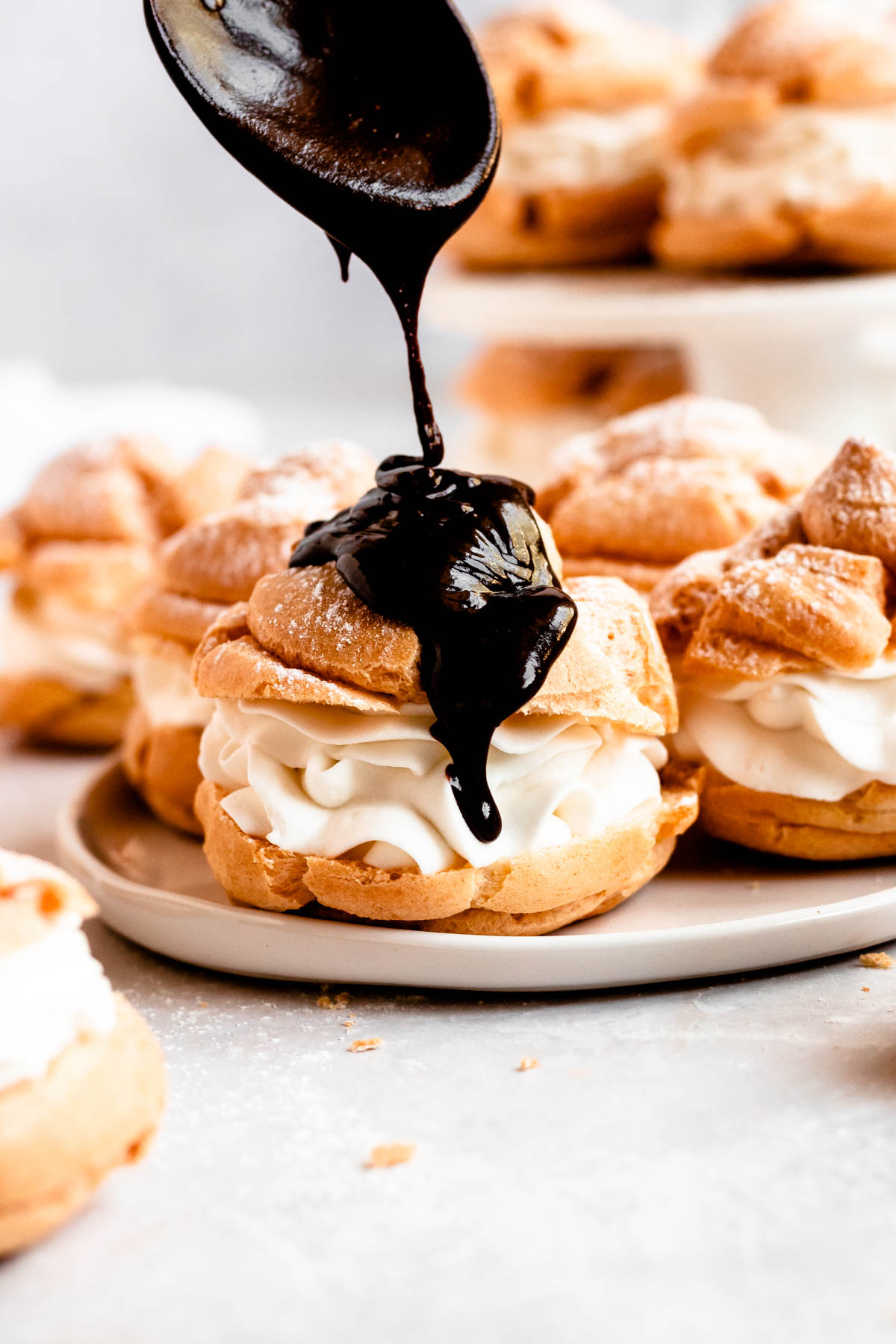 Close up shot of chocolate covered cream puffs.