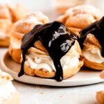 Cream puffs with chocolate on top.