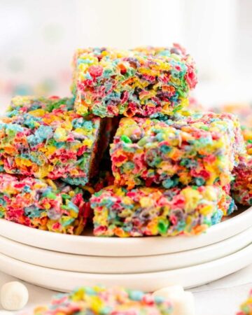Stack of fruity pebbles treats on a plate.