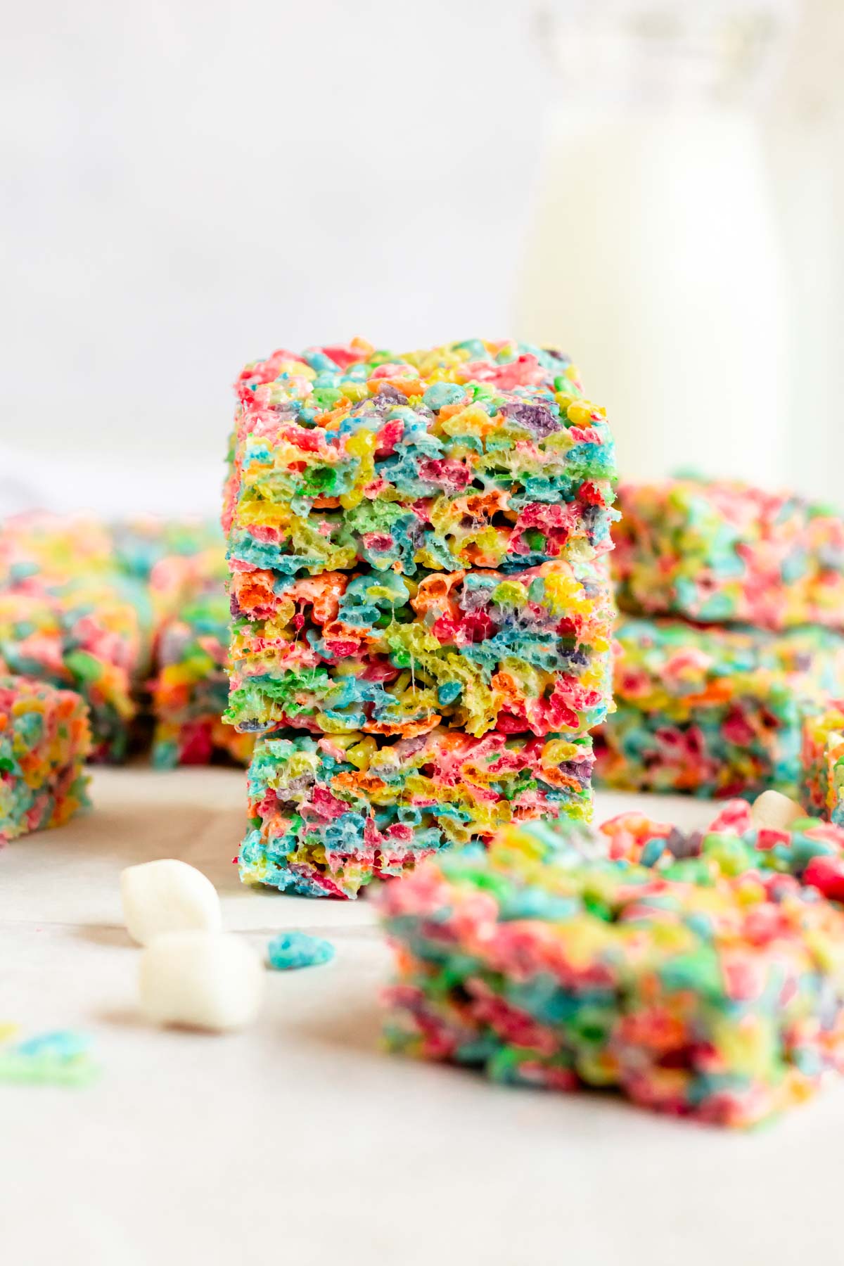 Stack of fruity pebbles treats on a parchment paper.