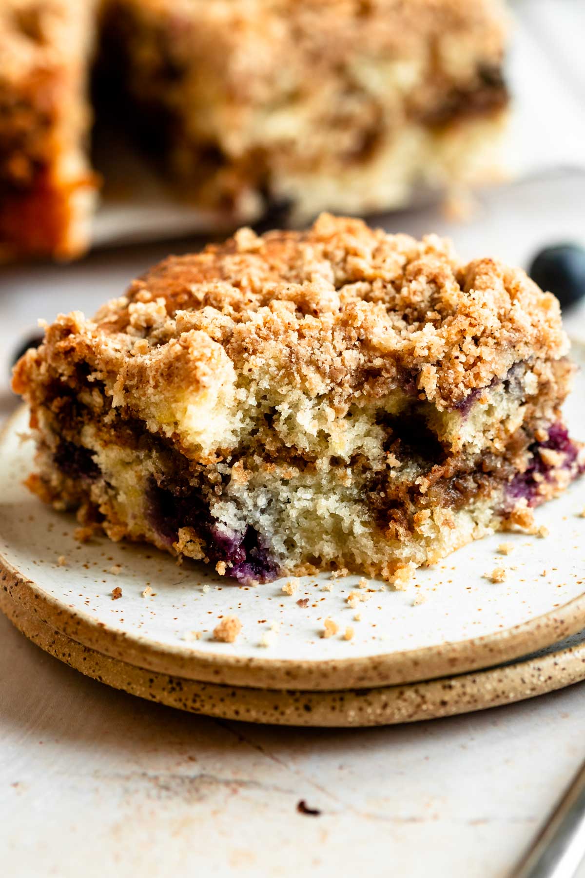 Slice of blueberry sour cream coffee cake on a plate.