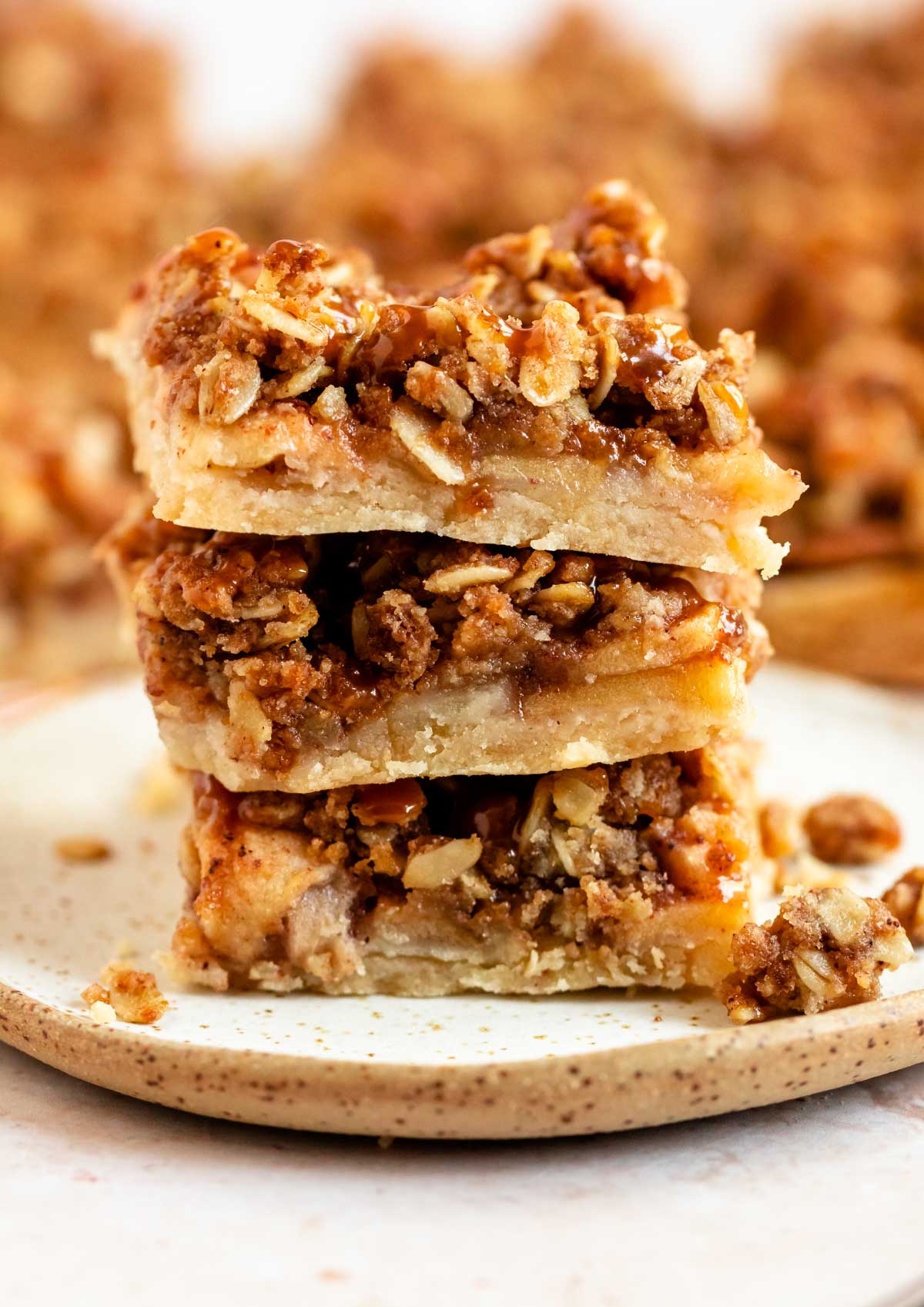 Stack of apple crumble bars on a plate.