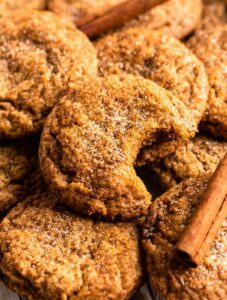 Close up shot of chewy pumpkin cookies with one cookie missing a bite.