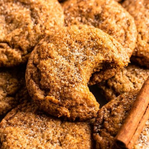 Close up shot of chewy pumpkin cookies with one cookie missing a bite.