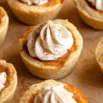 Mini pumpkin pies with whipped cream on top.