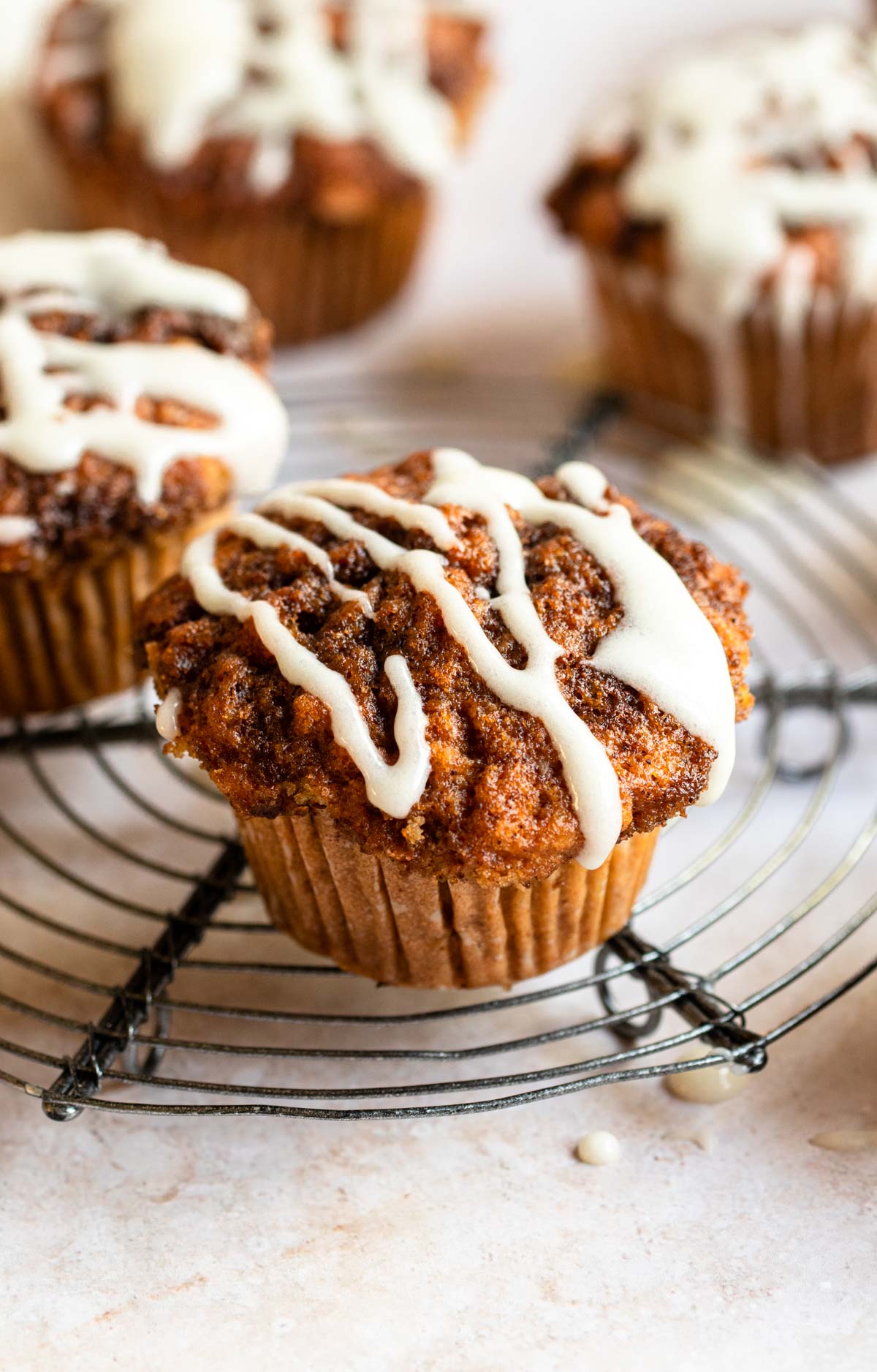 Cinnamon roll muffins on a cooling rack.
