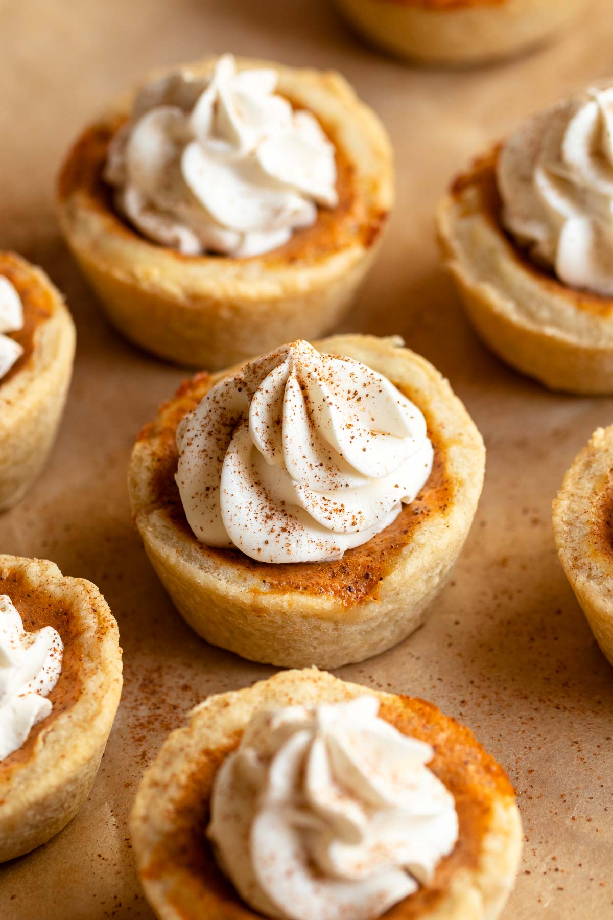 Mini pumpkin pies with whipped cream on top.