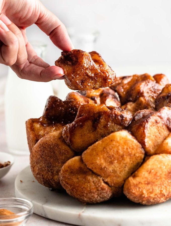 Hand lifting a piece of pull apart monkey bread.