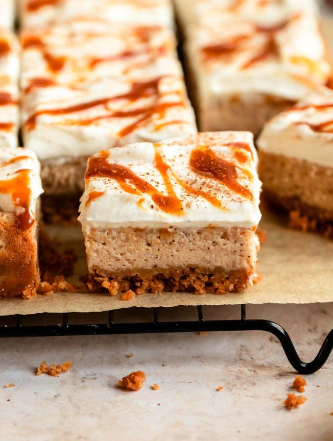 Sliced pumpkin cheesecake bars on a parchment paper.