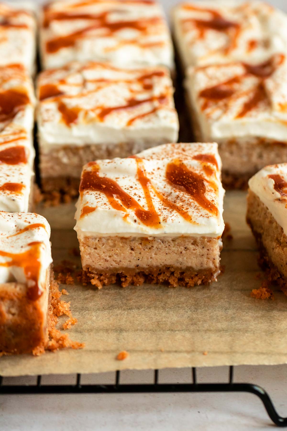 Sliced pumpkin cheesecake bars on a parchment paper.