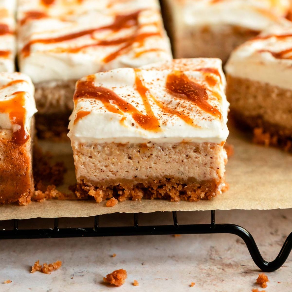 Sliced pumpkin cheesecake bars on a parchment paper.