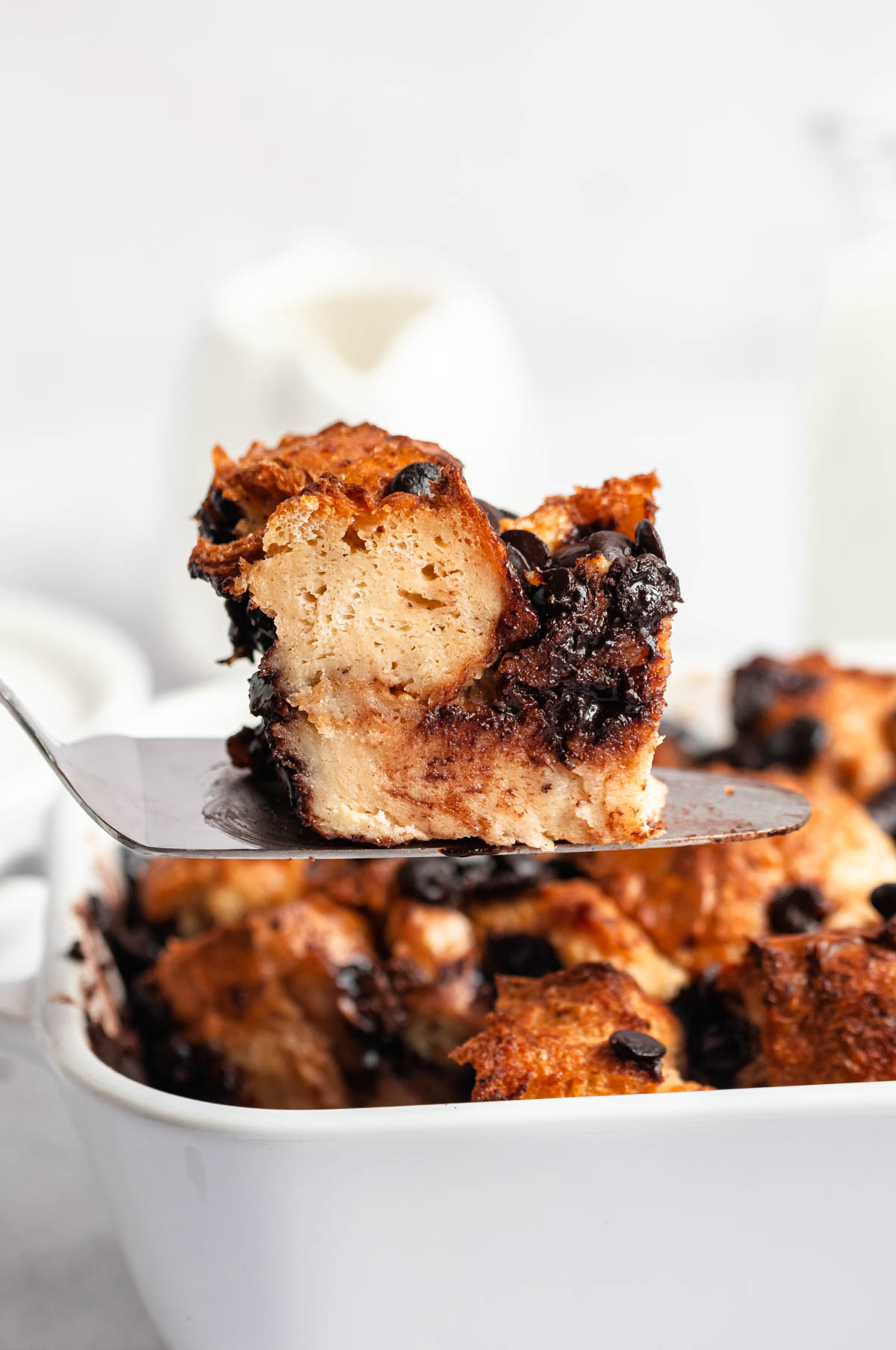 Close up shot of a slice of chocolate chip bread pudding.