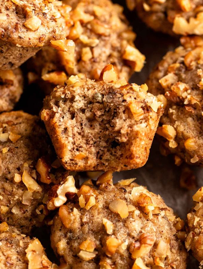 Close up shot of banana mini muffins with a bite missing from the middle one.